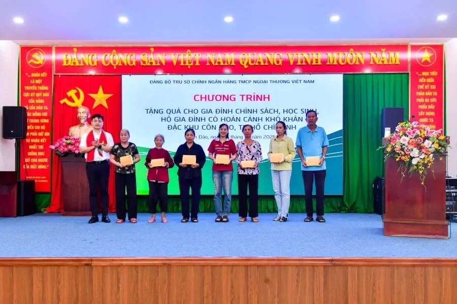 Đồng chí Nguyễn Danh Phương - Phó Bí thư thường trực Đảng ủy Vietcombank (ngoài cùng bên trái) trao quà cho các hộ gia đình có hoàn cảnh khó khăn