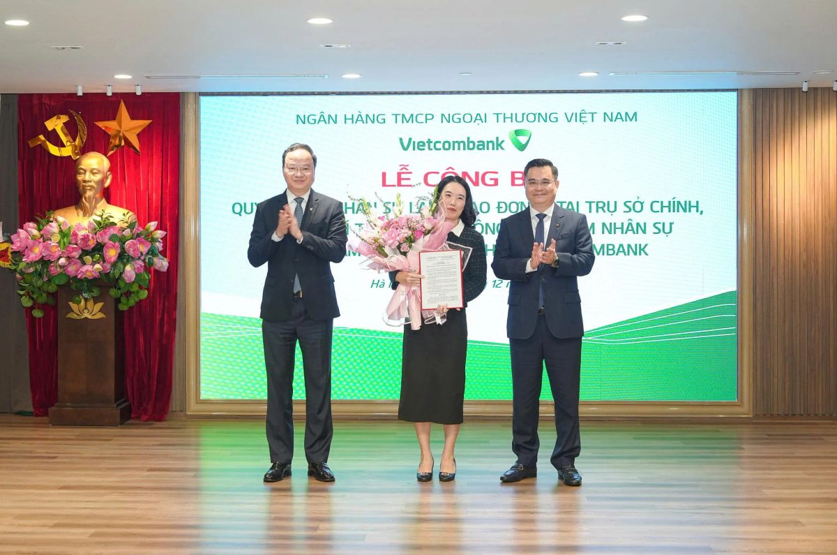 Ông Nguyễn Thanh Tùng - Ủy viên BCH Đảng bộ Chính phủ, Bí thư Đảng ủy, Chủ tịch HĐQT (bên phải) trao quyết định và ông Lê Quang Vinh - Phó Bí thư Đảng ủy, Thành viên HĐQT, Tổng Giám đốc (bên trái) tặng hoa chúc mừng bà Trần Thị Thanh Hoa - Phó Trưởng phòng phụ trách điều hành Phòng Quản lý rủi ro hoạt động Trụ sở chính