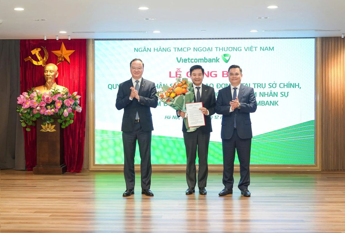 Ông Nguyễn Thanh Tùng - Ủy viên BCH Đảng bộ Chính phủ, Bí thư Đảng ủy, Chủ tịch HĐQT (bên phải) trao quyết định và ông Lê Quang Vinh - Phó Bí thư Đảng ủy, Thành viên HĐQT, Tổng Giám đốc (bên trái) tặng hoa chúc mừng ông Trần Mạnh Hùng - tân Bí thư Đảng ủy, Giám đốc Vietcombank Chương Dương