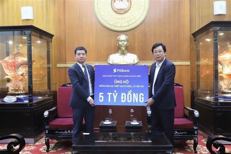 Ông Nguyễn Văn Hương - Thành viên HĐQT kiêm Tổng Giám đốc trao bảng tượng trưng 05 tỷ đồng ủng hộ của Ngân hàng đến đại diện UBMTTQVN