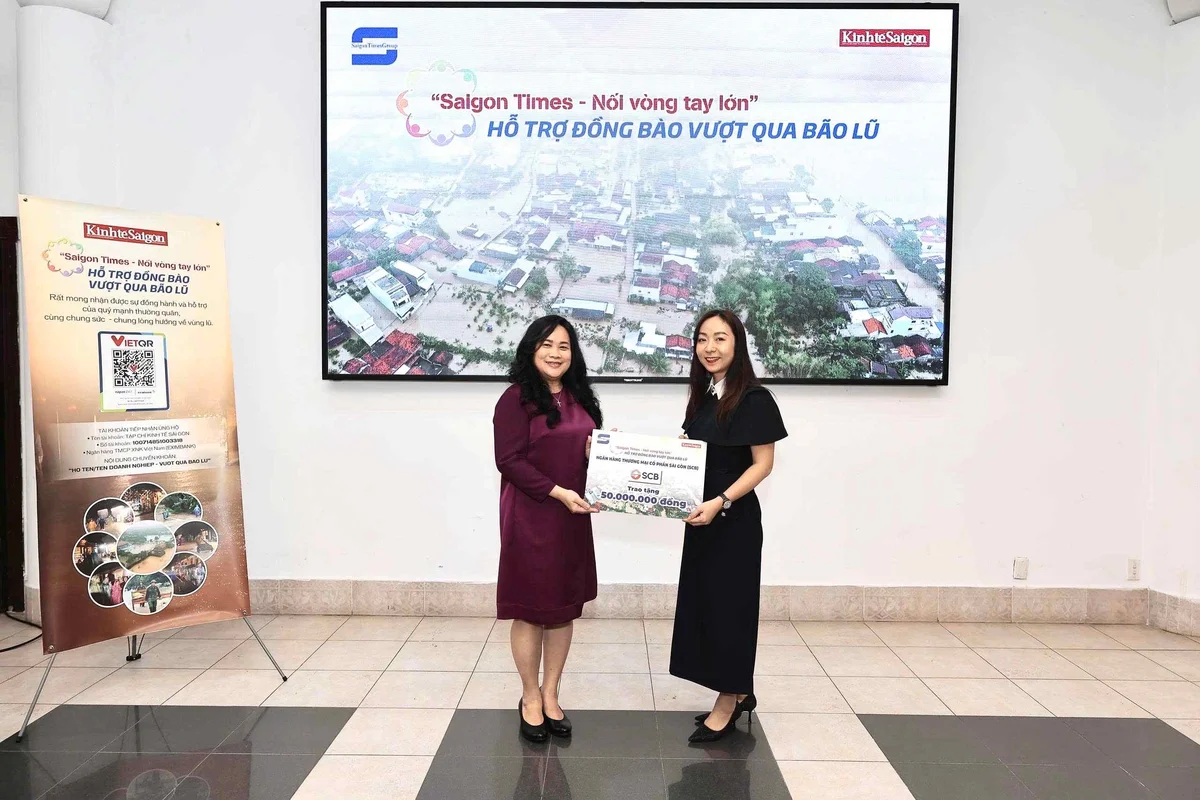Bà Nguyễn Hồ Thu Thủy (phải), Giám đốc Khối Pháp Chế, kiêm Chủ tịch Công đoàn Cơ sở SCB, trao bảng tượng trưng khoản ủng hộ 50 triệu đồng cho chương trình “Saigon Times - Nối vòng tay lớn – Hỗ trợ đồng bào vượt qua bão lũ” cho đại diện Tạp chí Kinh tế Sài Gòn (Saigon Times Group). Ảnh: Đạt Thành