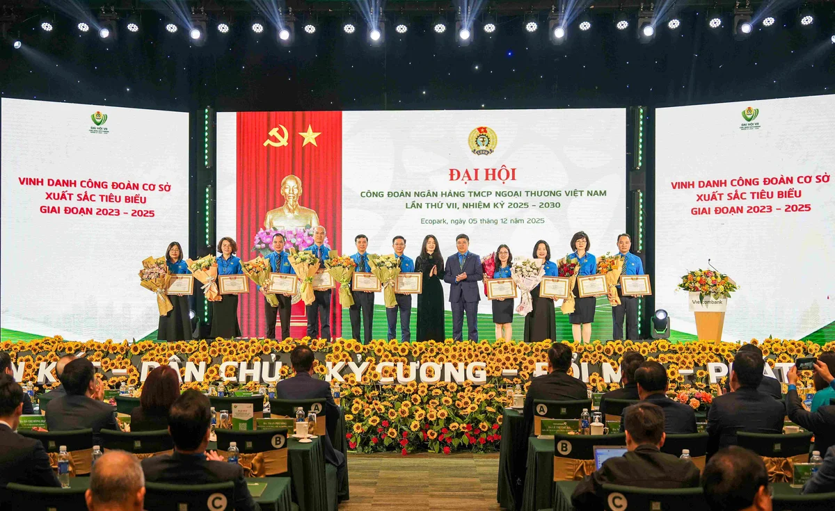 Ông Hồng Quang - Chủ tịch Công đoàn Vietcombank (thứ 5 từ phải sang) và bà Nguyễn Khánh Chi - Phó Chủ tịch Thường trực Công đoàn NHVN (thứ 7 từ trái sang) trao giấy khen và tặng hoa chúc mừng 10 tập thể