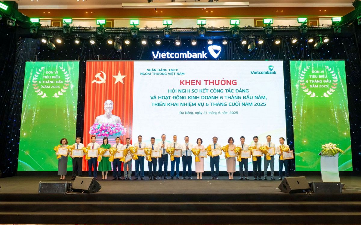 Đ/c Nguyễn Thanh Tùng - Bí thư Đảng ủy, Chủ tịch HĐQT Vietcombank (thứ 8 từ phải sang) và đ/c Lê Quang Vinh - Phó Bí thư Đảng ủy, Tổng Giám đốc Vietcombank (thứ 9 từ trái sang) trao giấy khen cho 16 chi nhánh tiêu biểu trong hoạt động kinh doanh 6 tháng đầu năm 2025
