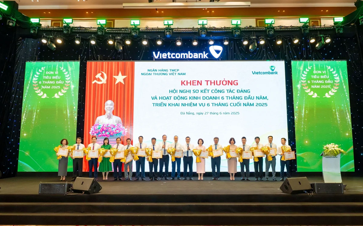 Đ/c Nguyễn Thanh Tùng - Bí thư Đảng ủy, Chủ tịch HĐQT Vietcombank (thứ 8 từ phải sang) và đ/c Lê Quang Vinh - Phó Bí thư Đảng ủy, Tổng Giám đốc Vietcombank (thứ 9 từ trái sang) trao giấy khen cho 16 chi nhánh tiêu biểu trong hoạt động kinh doanh 6 tháng đầu năm 2025