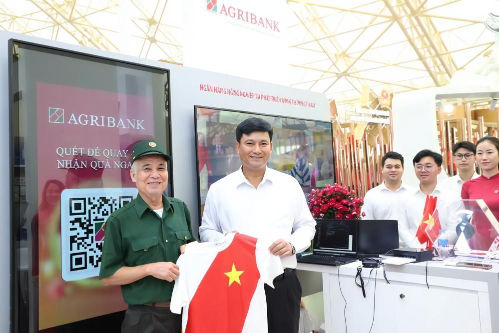 Ông Phạm Toàn Vượng, Tổng giám đốc Agribank tặng quà cho khách đến tham quan gian hàng triển lãm của Agribank