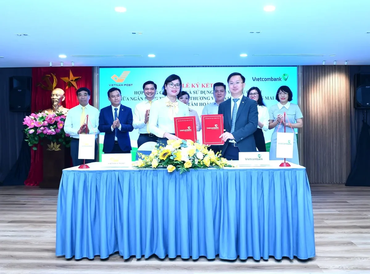 Ông Nguyễn Đình Minh - Phó Giám đốc Vietcombank Hoàng Mai (bên phải) và bà Nguyễn Thị Thanh Vân - Giám đốc Bưu điện Trung tâm Hoàn Kiếm thực hiện nghi thức ký kết trước sự chứng kiến của lãnh đạo các đơn vị
