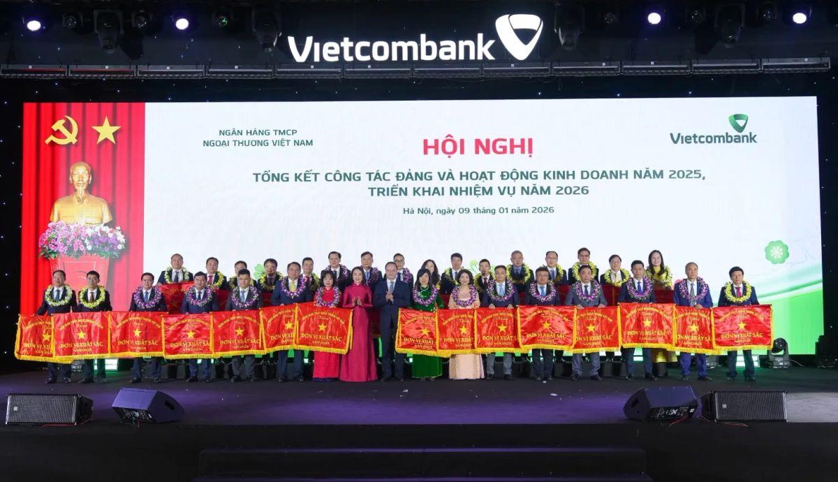 Đ/c Lê Quang Vinh - Phó Bí thư Đảng ủy, Thành viên HĐQT, Tổng Giám đốc Vietcombank (thứ 9 từ trái sang, hàng đầu) và đ/c Nguyễn Thị Kim Oanh - Ủy viên BTV Đảng ủy, Thành viên HĐQT Vietcombank (thứ 8 từ trái sang, hàng đầu) trao cờ và tặng hoa chúc mừng 31 chi nhánh “hoàn thành xuất sắc nhiệm vụ” năm 2025