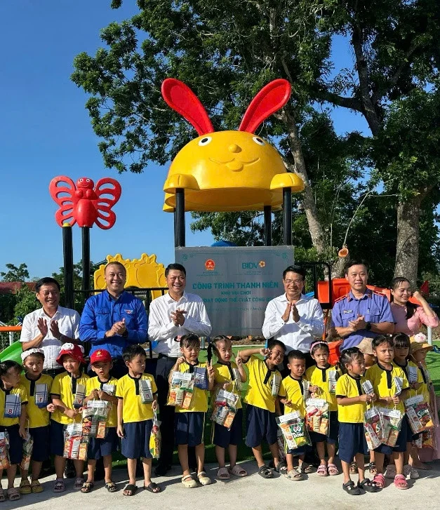 Đoàn công tác 2 đơn vị chụp ảnh lưu niệm với học sinh tại công trình vui chơi, rèn luyện sức khỏe cộng đồng ở thôn Thọ Lộc, xã Bố Trạch