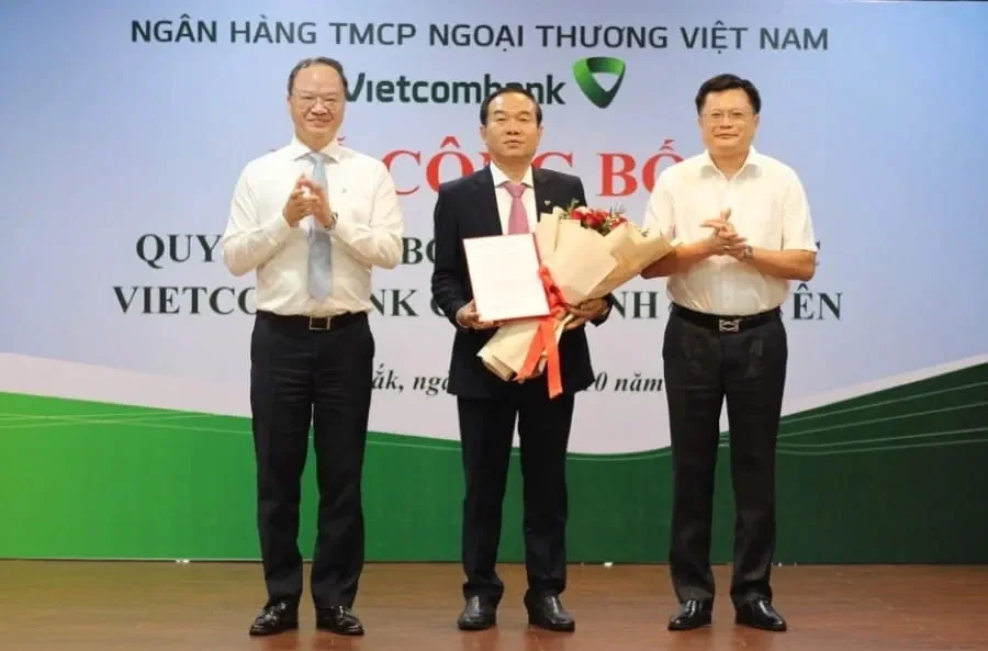 Ông Lê Quang Vinh - Phó Bí thư Đảng ủy, Thành viên HĐQT kiêm Tổng Giám đốc Vietcombank (bên trái) trao quyết định bổ nhiệm và ông Hoàng Linh - Phó Giám đốc NHNN Việt Nam Chi nhánh Khu vực 11 (bên phải) tặng hoa chúc mừng ông Lê Hải Bắc - tân Giám đốc Vietcombank Phú Yên