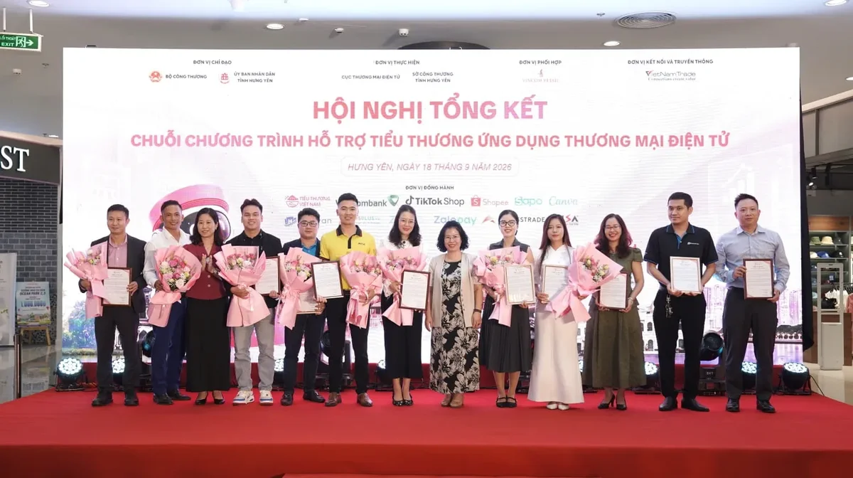 Đại diện Vietcombank, bà Lê Mai Nga - Trưởng phòng Quản lý kênh chi nhánh (thứ 7 từ trái sang) nhận hoa và thư cảm ơn từ Ban tổ chức, ghi nhận những đóng góp tích cực của ngân hàng trong hành trình đồng hành, hỗ trợ tiểu thương ứng dụng thương mại điện tử
