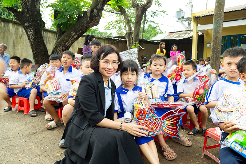 Bà Trần Thị Lý, Phó Tổng giám đốc Vietbank, trao quà cho các em học sinh Trường Tiểu học Nguyễn Thị Lắng - Phân hiệu Bến Đò