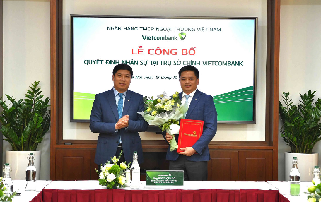 Ông Hồng Quang - Thành viên HĐQT kiêm Giám đốc Khối Nhân sự Vietcombank (bên trái) trao quyết định bổ nhiệm và tặng hoa chúc mừng ông Nguyễn Kiên Hiếu