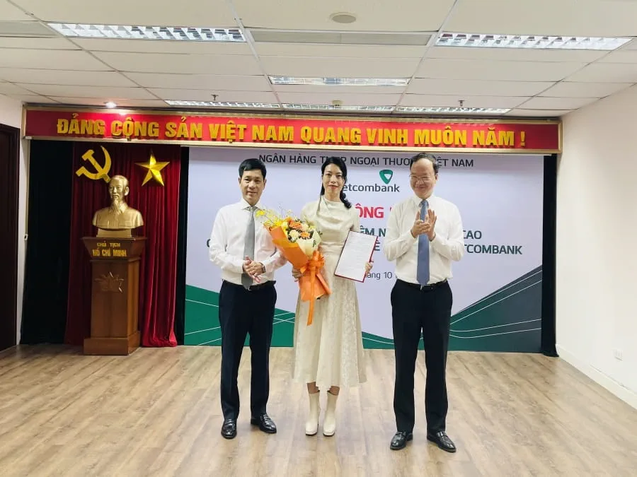 Phó Tổng Giám đốc Vietcombank Lê Quang Vinh (bên phải) trao quyết định và ông Nguyễn Trung Hà - Chủ tịch HĐTV VCBL (bên trái) tặng hoa chúc mừng bà Nguyễn Ngọc Trâm - tân Thành viên HĐTV VCBL