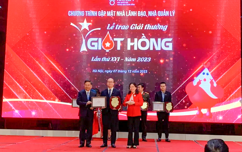 PGS.TS Nguyễn Hà Thanh - Viện trưởng Viện Huyết học Truyền máu Trung ương (bên trái) trao giấy chứng nhận và biểu trưng cho đ/c Dương Bảo Trung - Bí thư Đoàn Thanh niên Vietcombank (đứng giữa) đối với thành tích xuất sắc Vietcombank đạt được trong công tác vận động, tổ chức hiến máu tình nguyện