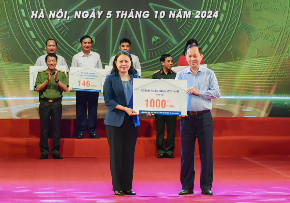 Phó Thống đốc Đào Minh Tú trao ủng hộ của ngành Ngân hàng Việt Nam cho chương trình xóa nhà tạm, nhà dột nát