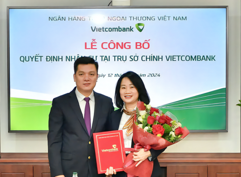 Ông Hồ Văn Tuấn - Phó Tổng Giám đốc trao quyết định bổ nhiệm và tặng hoa chúc mừng bà Lê Vân Trinh - tân Phó Giám đốc Trung tâm hỗ trợ khách hàng TSC Vietcombank