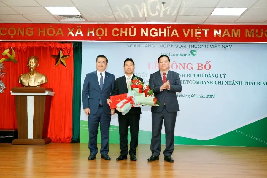Ông Nguyễn Thanh Tùng - Phó Bí thư phụ trách Đảng bộ, Tổng Giám đốc Vietcombank (ngoài cùng bên trái) trao quyết định bổ nhiệm và ông Nguyễn Khắc Thận - Phó Bí thư Tỉnh uỷ, Chủ tịch UBND tỉnh Thái Bình (ngoài cùng bên phải) tặng hoa chúc mừng ông Nguyễn Thanh Hải - tân Giám đốc Vietcombank Thái Bình