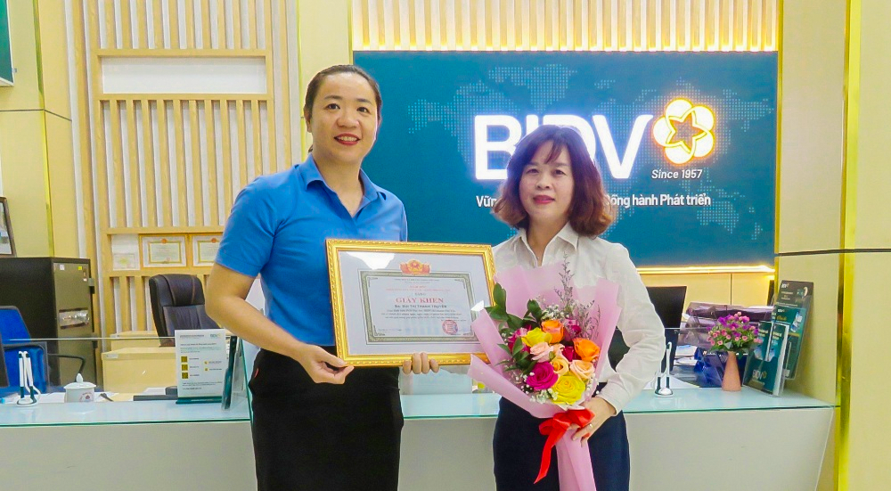 Bà Đỗ Thị Bích Diệu, Phó Giám đốc NHNN chi nhánh tỉnh Phú Yên trao giấy khen cho giao dịch viên Bùi Thị Thanh Truyền.