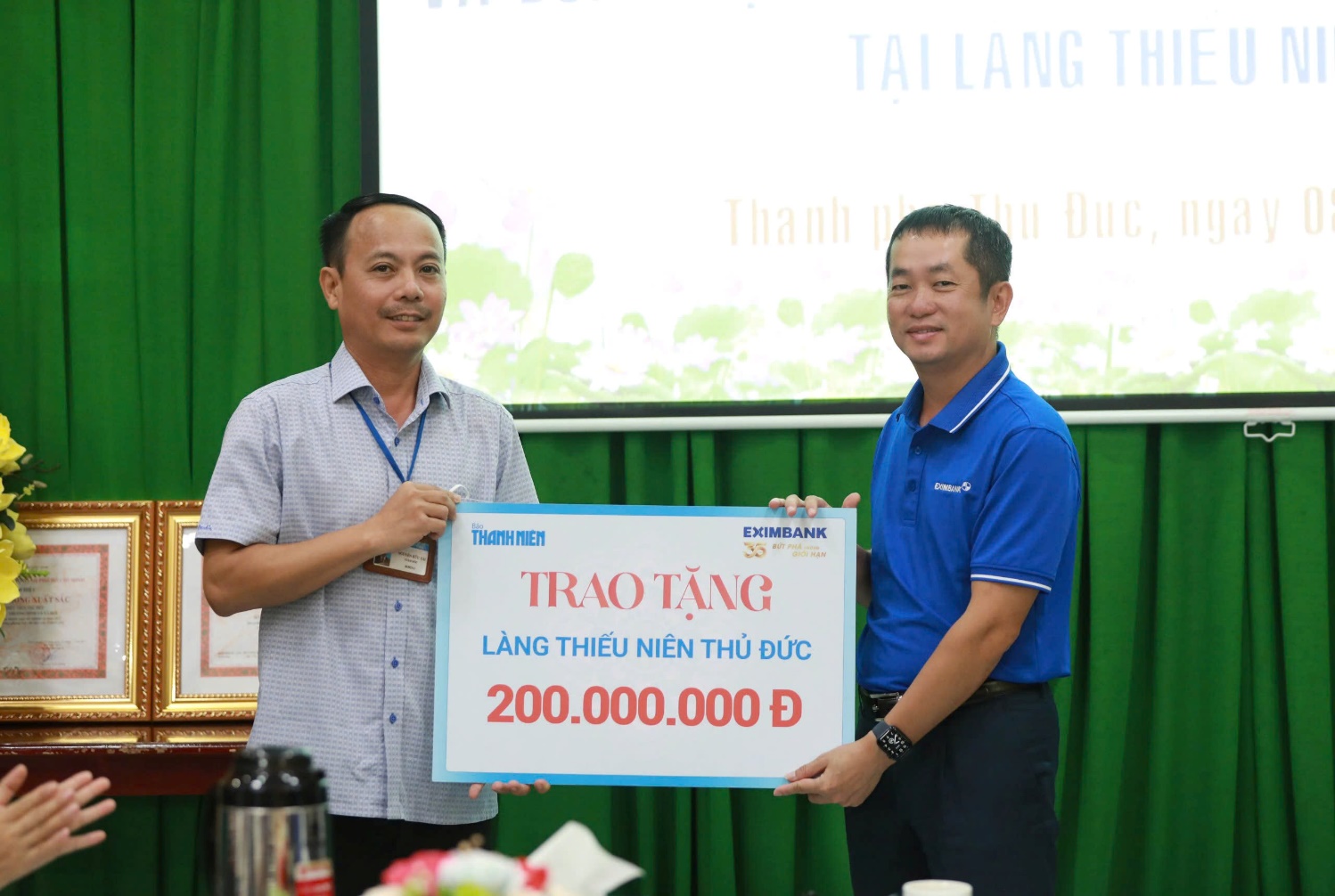 Ông Nguyễn Hướng Minh – Phó Tổng Giám đốc Eximbank (bên phải) trao quà cho đại diện Làng Thiếu niên Thủ Đức.