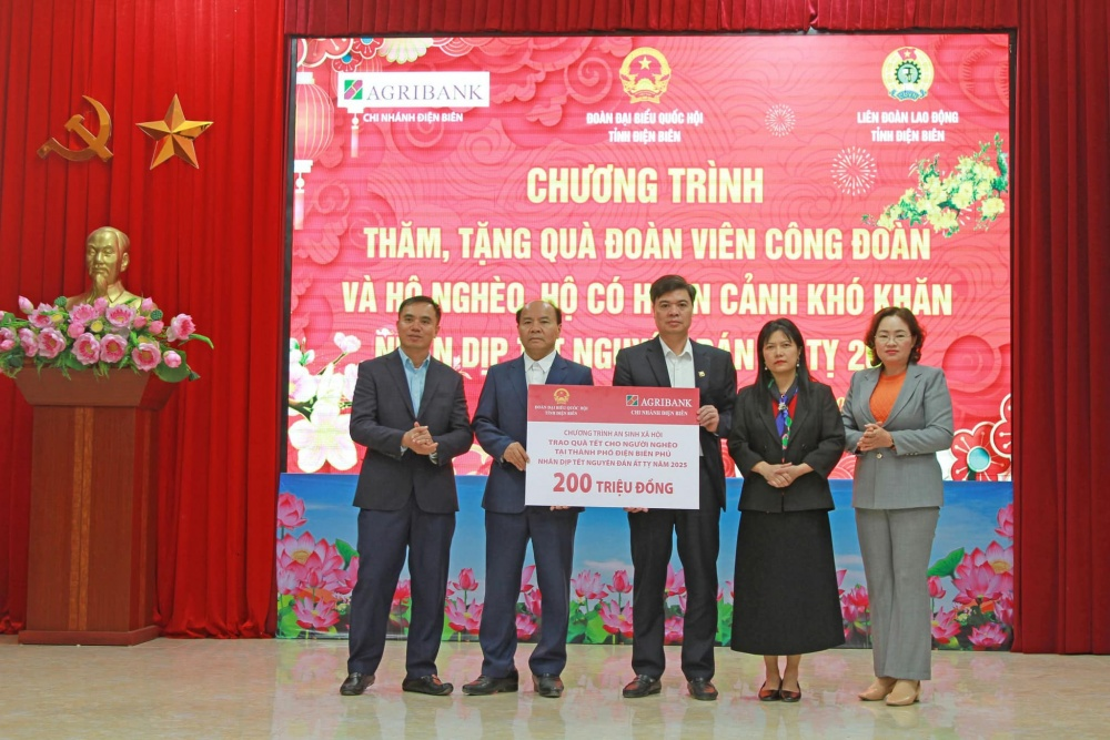 Đại diện Agribank Chi nhánh tỉnh Điện Biên trao biển tượng trưng tặng quà Tết cho người người nghèo tại Thành phố Điện Biên Phủ số tiền 200 triệu đồng