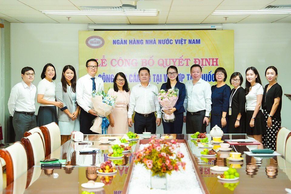 Các đồng chí nhận nhiệm vụ mới nhận hoa chúc mừng của Lãnh đạo NHNN và tập thể Vụ HTQT