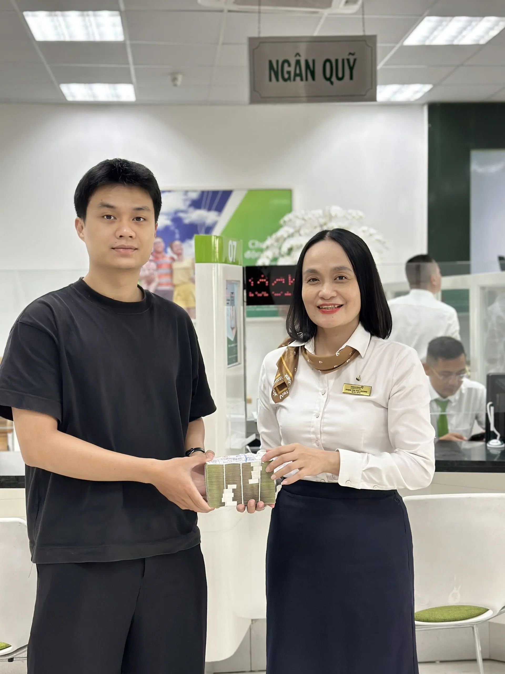Chị Phạm Thị Thu Hương - Phó phòng Hành chính nhân sự Ngân quỹ Vietcombank Nam Đà Nẵng (bên phải) hoàn trả 100 triệu đồng cho khách hàng