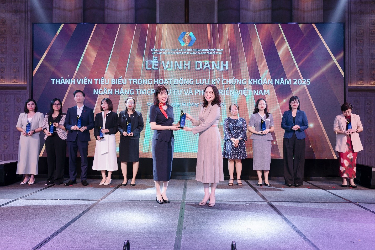 Bà Phạm Vũ Thiên Nga - Giám đốc Ban Định chế Tài chính BIDV thay mặt ngân hàng nhận biểu trưng “Thành viên tiêu biểu trong hoạt động Lưu ký chứng khoán”