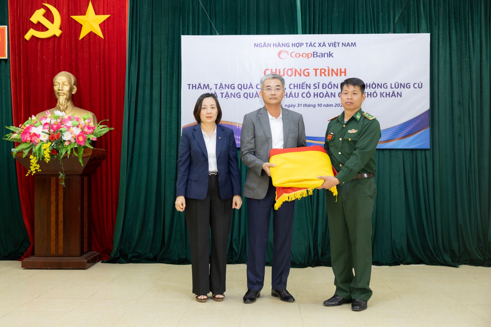 Ông Nguyễn Quốc Cường - Chủ tịch Hội đồng quản trị Co-opBank và bà Phạm Thị Hồng Minh - Tổng giám đốc Co-opBank đã trân trọng trao tặng 05 lá cờ Tổ quốc khổ lớn với diện tích 54m² cho Đồn Biên phòng Lũng Cú