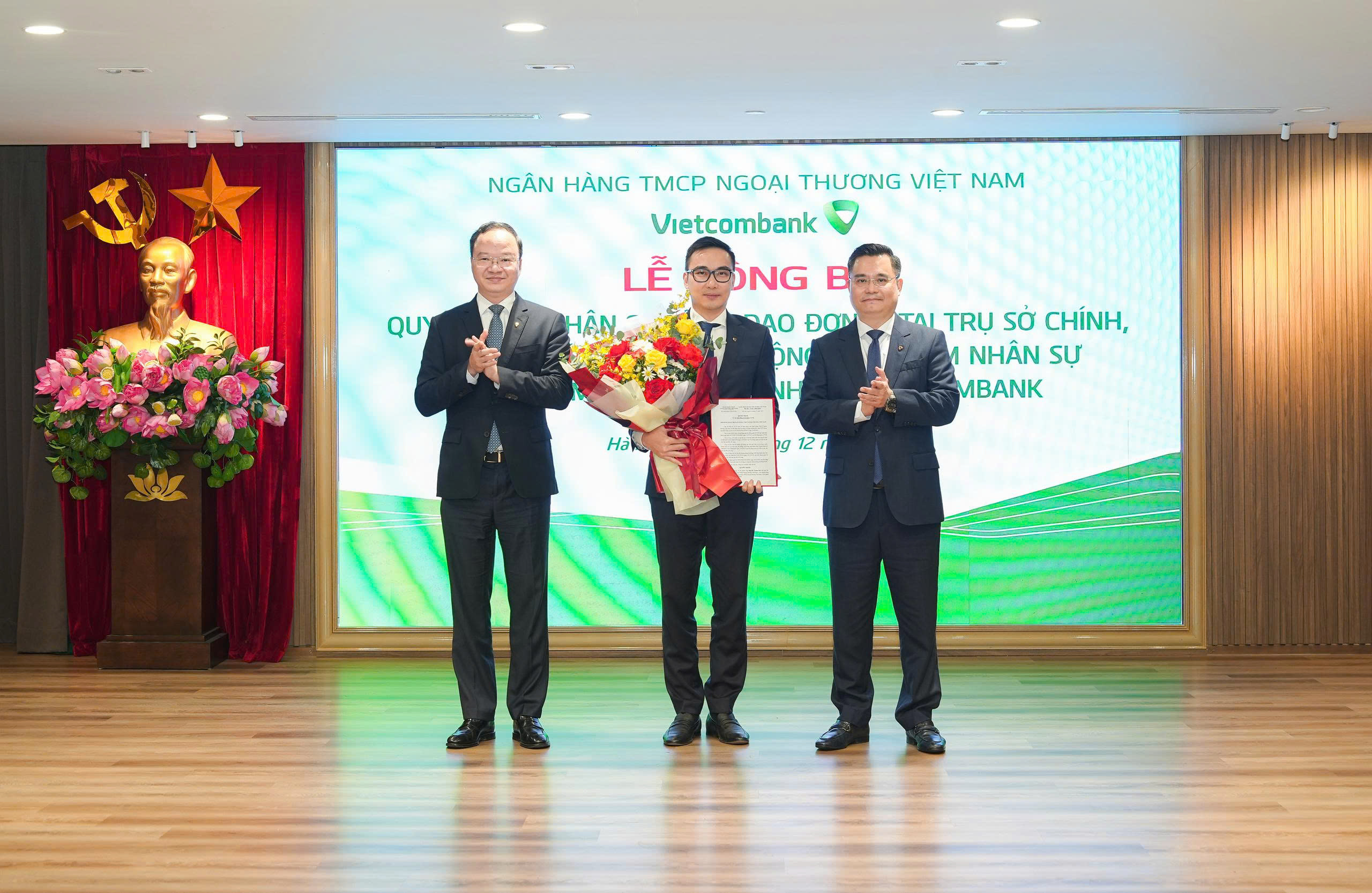 Ông Nguyễn Thanh Tùng - Ủy viên BCH Đảng bộ Chính phủ, Bí thư Đảng ủy, Chủ tịch HĐQT (bên phải) trao quyết định và ông Lê Quang Vinh - Phó Bí thư Đảng ủy, Thành viên HĐQT, Tổng Giám đốc (bên trái) tặng hoa chúc mừng ông Nguyễn Trung Hải - tân Bí thư Đảng ủy, Giám đốc Vietcombank Hải Phòng