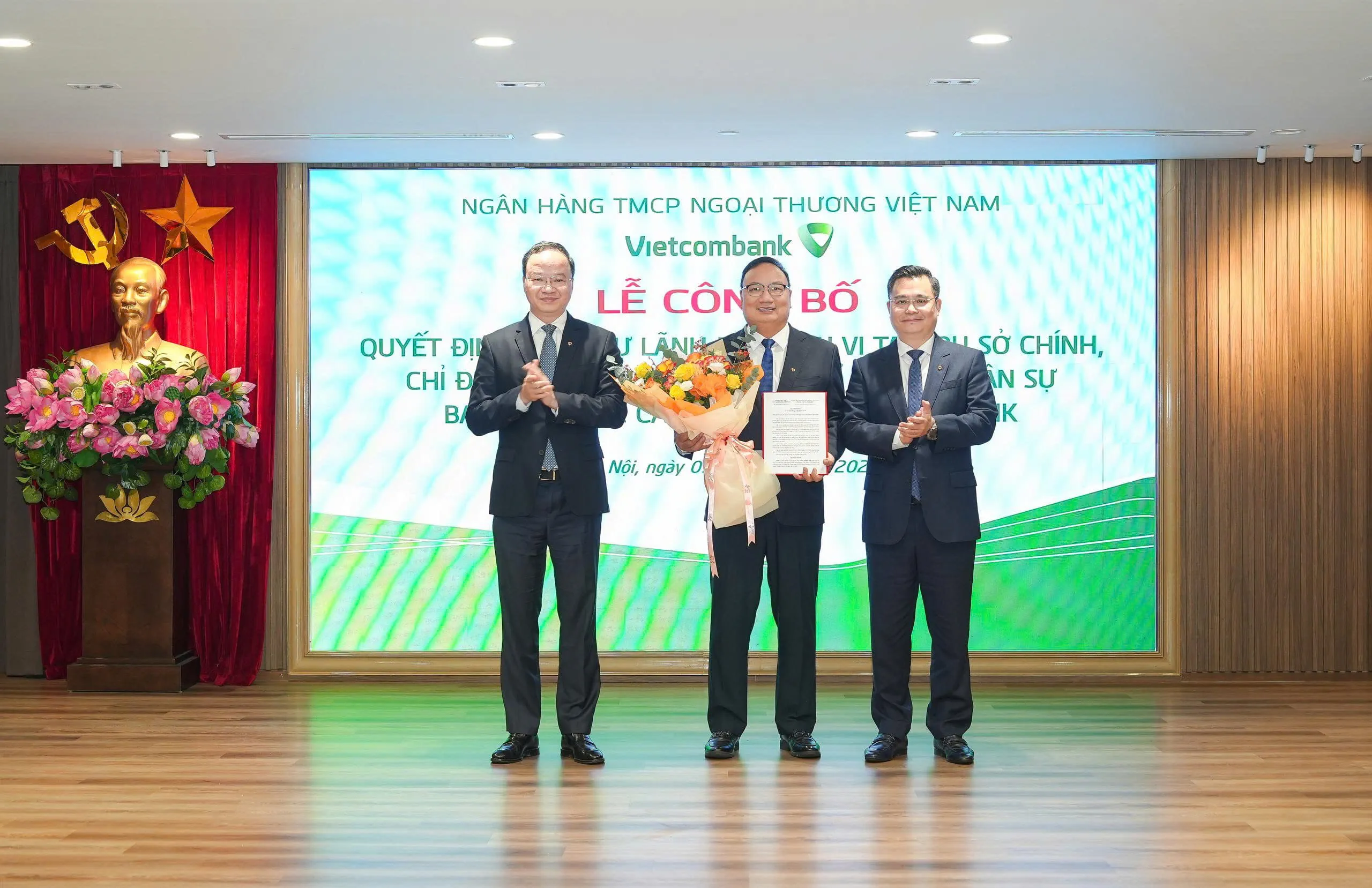 Ông Nguyễn Thanh Tùng - Ủy viên BCH Đảng bộ Chính phủ, Bí thư Đảng ủy, Chủ tịch HĐQT (bên phải) trao quyết định và ông Lê Quang Vinh - Phó Bí thư Đảng ủy, Thành viên HĐQT, Tổng Giám đốc (bên trái) tặng hoa chúc mừng ông Thiều Quang Hiệp - tân Bí thư Đảng ủy, Giám đốc Vietcombank Thăng Long