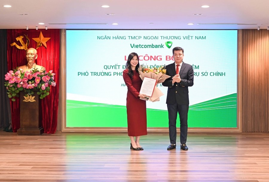 Ông Hồ Văn Tuấn - Phó Tổng Giám đốc Vietcombank trao quyết định, tặng hoa chúc mừng bà Phạm Thị Mai Hương - tân Phó Trưởng phòng Phê duyệt tín dụng Trụ sở chính