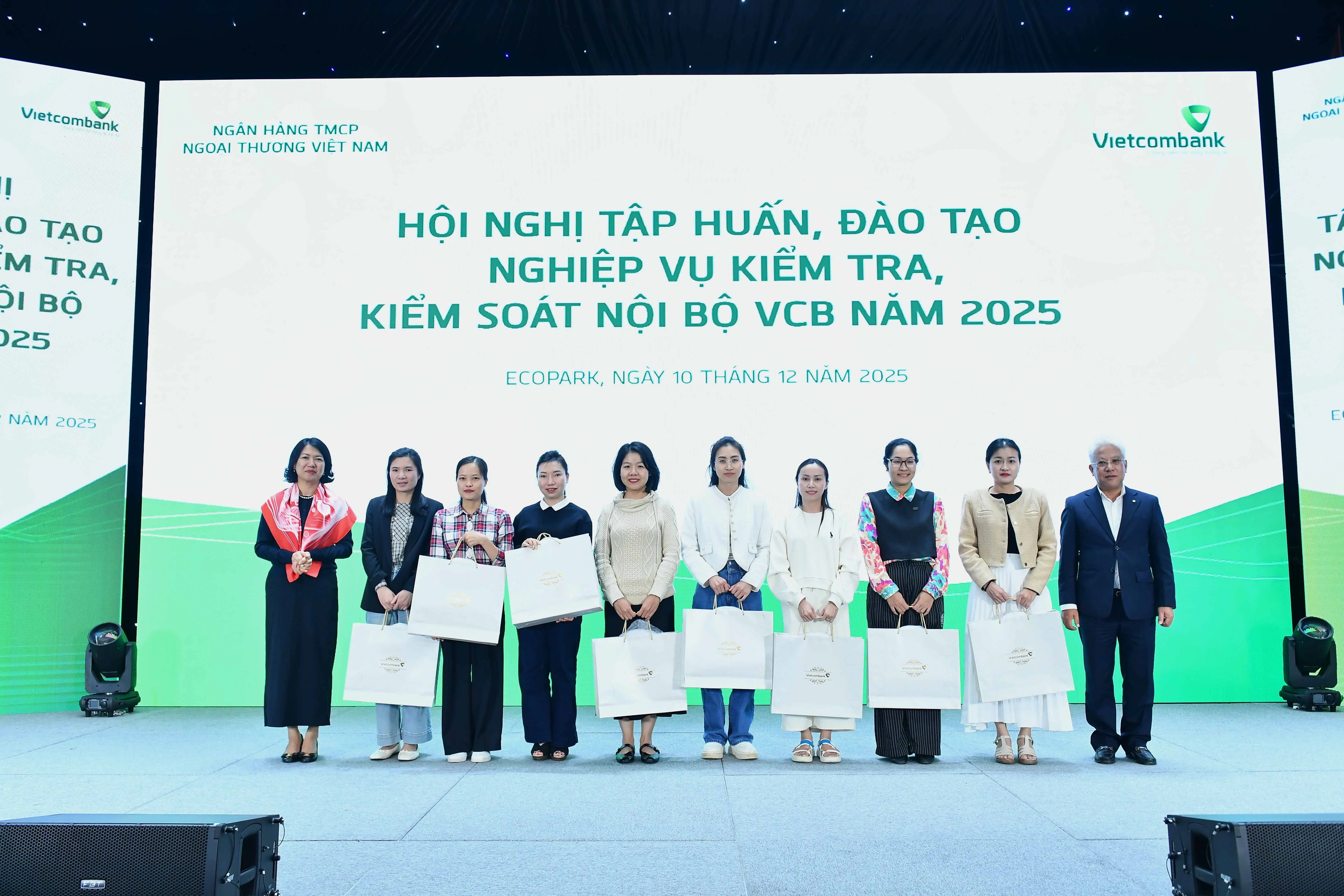 Bà Nguyễn Thị Hồng Vân - Thành viên Ban điều hành, Giám đốc Khối Pháp chế và Tuân thủ (ngoài cùng bên trái) và ông Nguyễn Ngọc Ban - Giám đốc Trường Đào tạo và phát triển nguồn nhân lực Vietcombank (ngoài cùng bên phải) tặng quà cho các học viên đạt giải Nhất