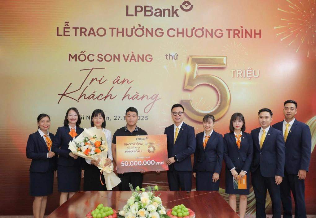 Đại diện ngân hàng trao tặng sổ tiết kiệm trị giá 50 triệu đồng cho ông Bùi Đức Doanh - khách hàng cá nhân thứ 5 triệu. Ảnh: LPBank