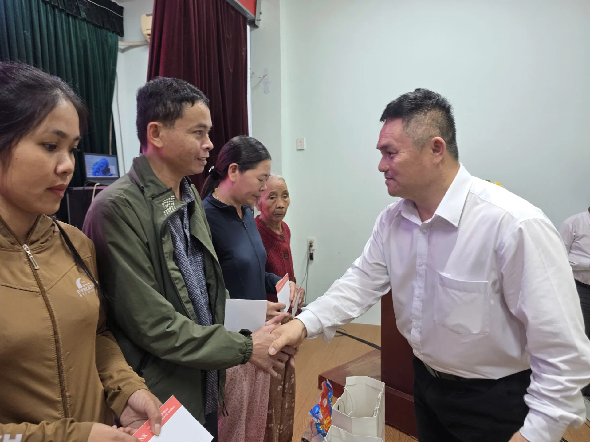 Ông Trần Hữu Trinh - Phó Trưởng Văn phòng đại diện Agribank khu vực miền Trung tặng quà cho người dân xã Hiệp Đức, thành phố Đà Nẵng. Ảnh: T.H.