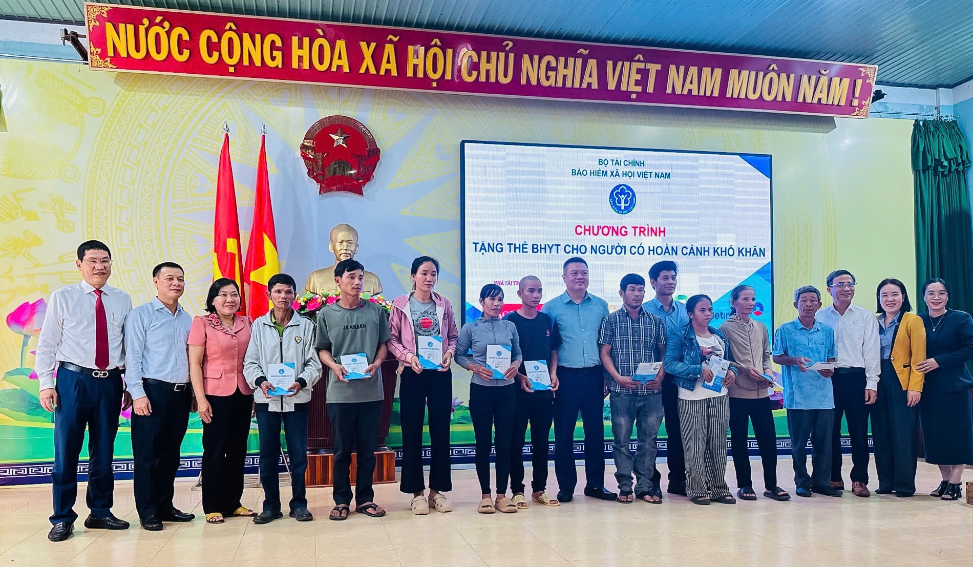 Ông Nguyễn Đắc Dũng - Phó Giám đốc Agribank Bình Định (ngoài cùng bên trái) trao tặng 110 thẻ BHYT cho bà con nhân dân xã Phù Mỹ Bắc