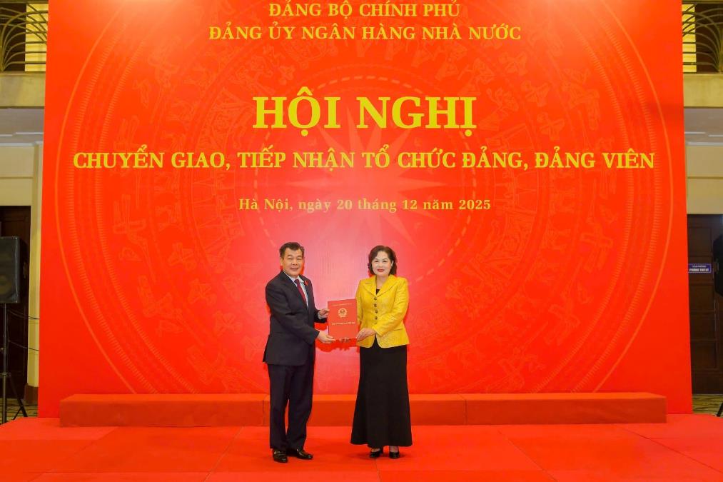 Đồng chí Nguyễn Đức Phong - Phó Bí thư Đảng ủy Chính phủ trao Quyết định chuyển giao các tổ chức đảng, đảng viên về Đảng ủy NHNN cho đồng chí Nguyễn Thị Hồng - Ủy viên TW Đảng, Bí thư Đảng ủy, Thống đốc NHNN