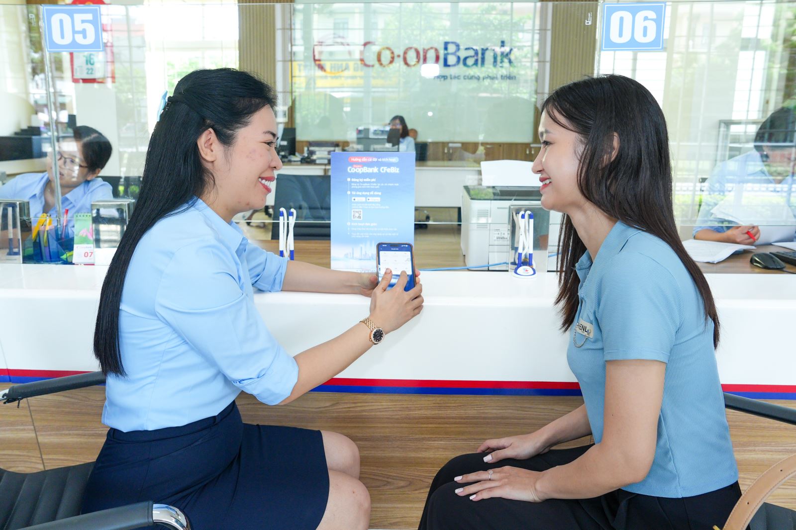 Cán bộ Co-opBank hướng dẫn khách hàng sử dụng dịch vụ Co-opBank Mobile Banking