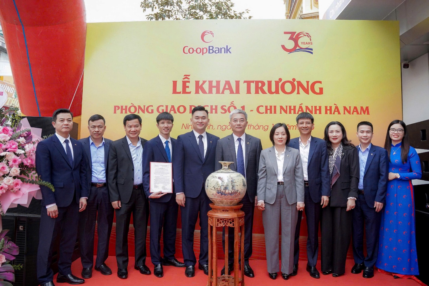 Ông Nguyễn Quốc Cường - Chủ tịch Hội đồng quản trị Co-opBank và bà Phạm Thị Hồng Minh - Thành viên Hội đồng quản trị, Tổng giám đốc Co-opBank trao Quyết định thành lập, quà và hoa tặng PGD số 1 - Co-opBank chi nhánh Hà Nam.