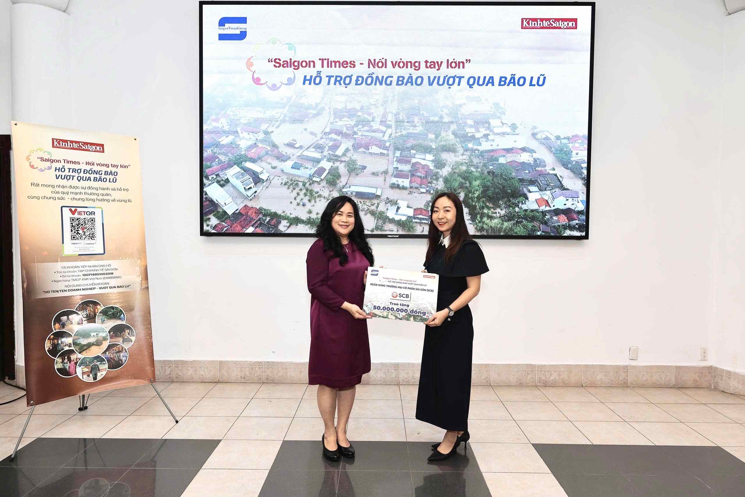 Bà Nguyễn Hồ Thu Thủy (phải), Giám đốc Khối Pháp Chế, kiêm Chủ tịch Công đoàn Cơ sở SCB, trao bảng tượng trưng khoản ủng hộ 50 triệu đồng cho chương trình “Saigon Times - Nối vòng tay lớn – Hỗ trợ đồng bào vượt qua bão lũ” cho đại diện Tạp chí Kinh tế Sài Gòn (Saigon Times Group). Ảnh: Đạt Thành