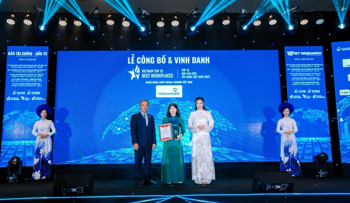 Đại diện Vietcombank, bà Nguyễn Hoàng Hà - Phó Trưởng phòng Chính sách và Kế hoạch nhân sự (đứng giữa) nhận giải thưởng “Top 10 Nơi làm việc tốt nhất Việt Nam ngành Ngân hàng năm 2025” (Vietcombank xếp thứ 1)