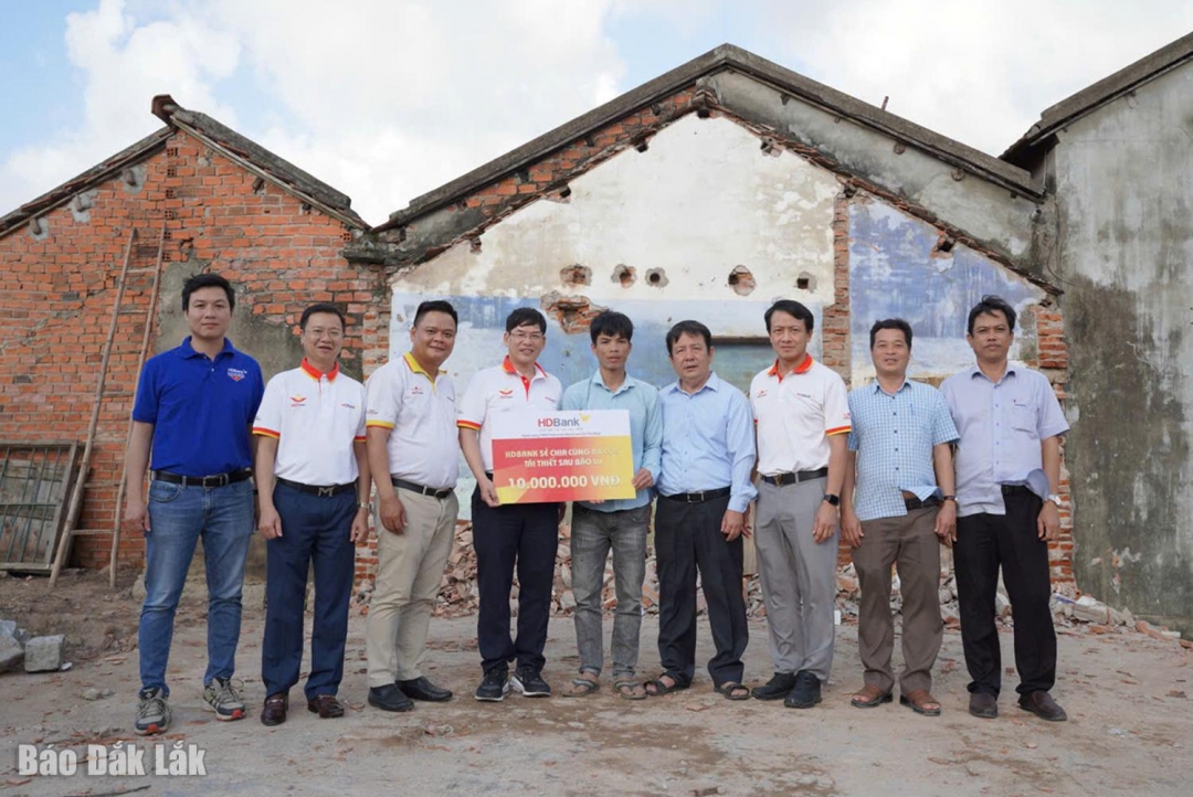 Đoàn công tác của HDBank trao 10 triệu đồng hỗ trợ cho một hộ dân ở xã Hòa Xuân.