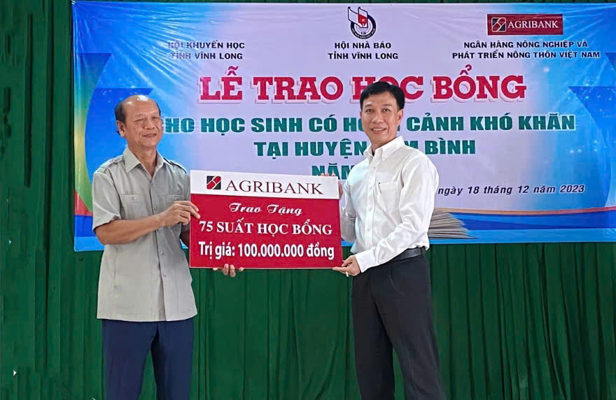 Agribank chi nhánh tỉnh Vĩnh Long (bên phải) trao biểu trưng 75 suất học bổng trị giá 100 triệu đồng tặng học sinh có hoàn cảnh khó khăn ở huyện Tam Bình cũ (Ảnh tư liệu)