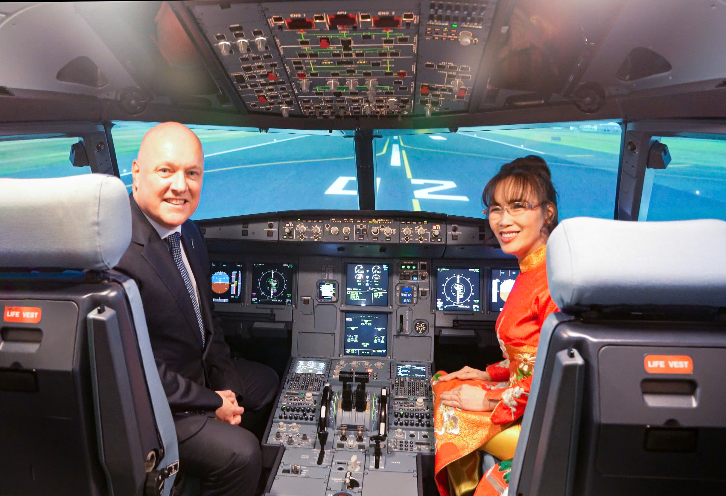 Thủ tướng New Zealand Christopher Luxon và Tiến sĩ Nguyễn Thị Phương Thảo điều khiển máy bay hạ cánh trong buồng lái mô phỏng tại Học viện Hàng không Vietjet.