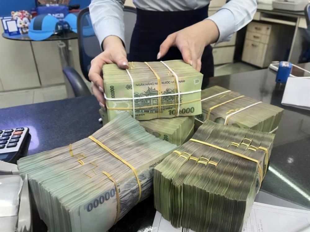 A bank employee counts money for a customer at a private bank branch in Ho Chi Minh City. Many commercial banks are optimistic about achieving their profit targets for 2025.
