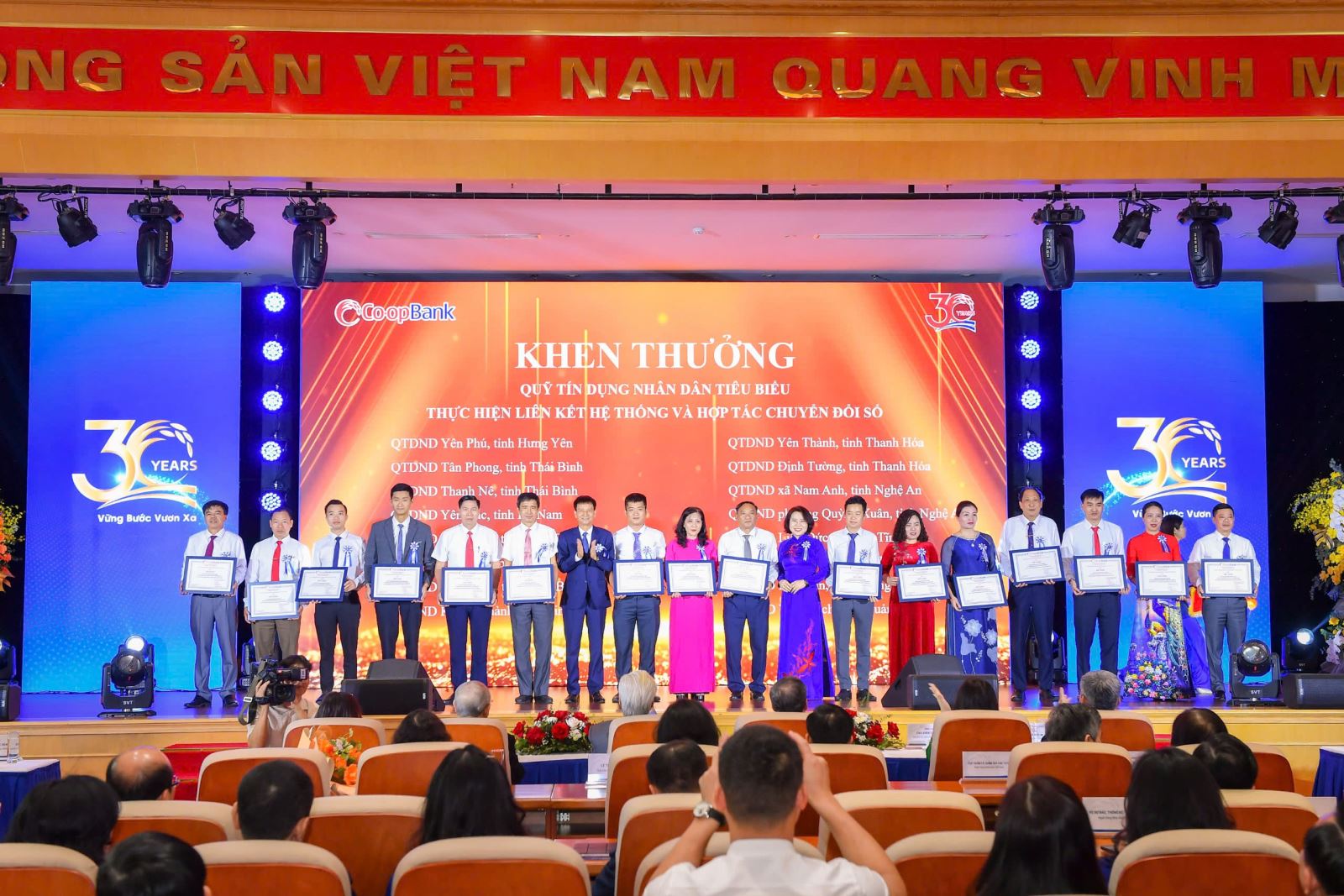Các đồng chí lãnh đạo Co-opBank trao vinh danh các QTDND thành viên thực hiện tốt mối liên kết hệ thống và hợp tác chuyển đổi số tại buổi lễ kỷ niệm 30 năm thành lập Co-opBank
