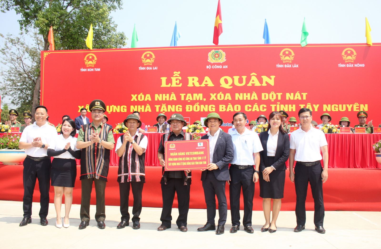 Ông Đặng Hoài Đức - Phó Tổng Giám đốc Vietcombank (thứ 4 từ phải sang) trao bảng tượng trưng tài trợ xây dựng nhà ở tặng đồng bào tỉnh Kon Tum trong chương trình xóa nhà tạm, nhà dột nát