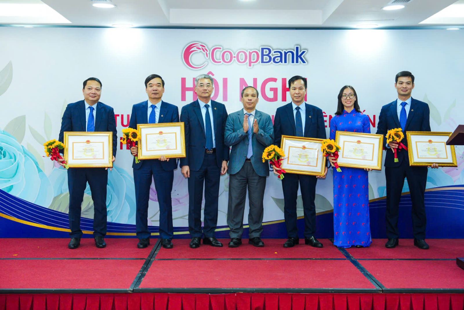 Đồng chí Đoàn Thái Sơn - Ủy viên Ban thường vụ Đảng ủy, Phó Thống đốc NHNN Việt Nam trao Bằng khen của Thống đốc NHNN Việt Nam và đồng chí Nguyễn Quốc Cường - Bí thư Đảng bộ, Chủ tịch HĐQT Co-opBank tặng hoa cho các cá nhân thuộc Co-opBank