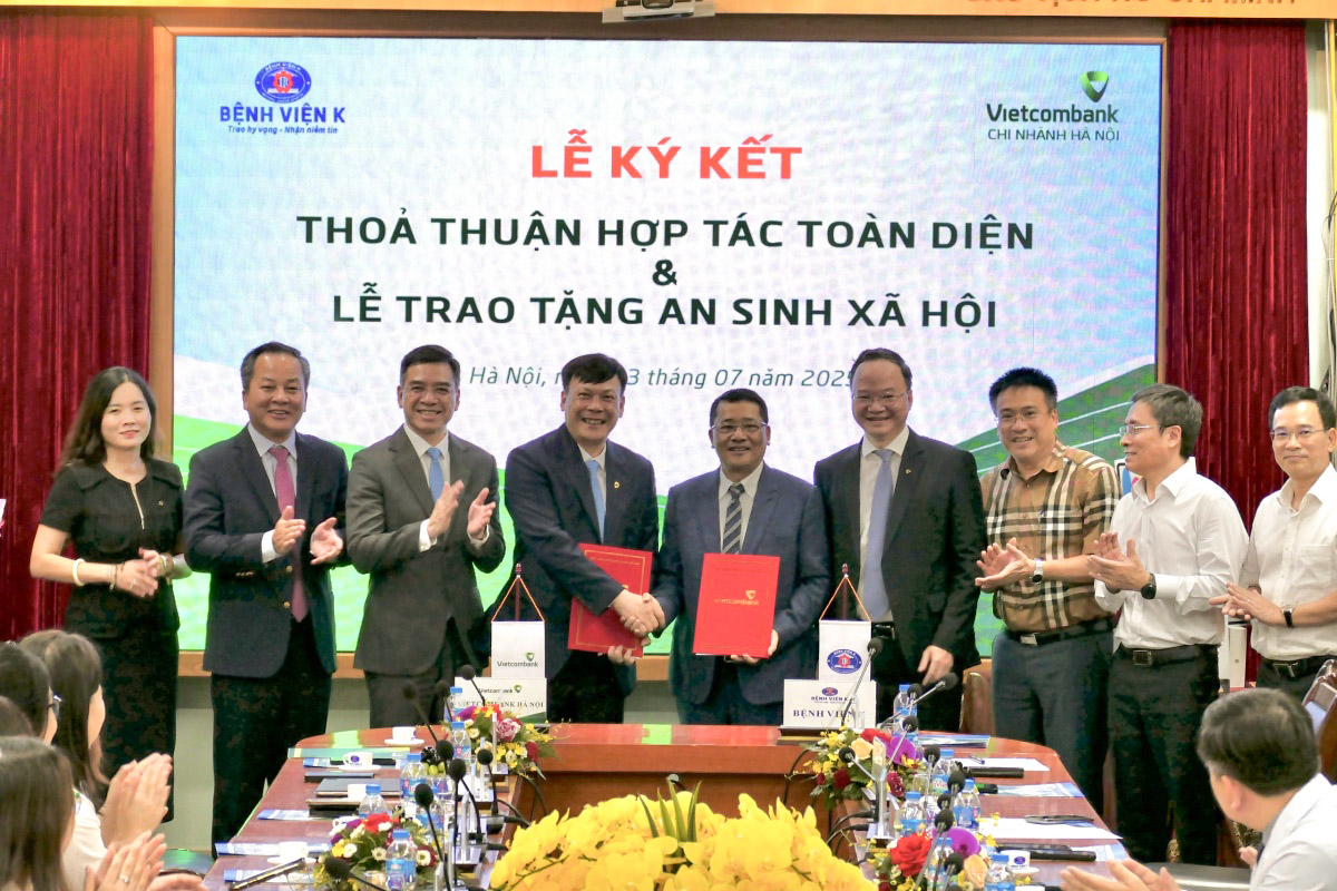 Ông Lê Văn Quảng - Giám đốc Bệnh viện K (thứ 5 phải qua) và ông Lê Ngọc Thái - Giám đốc Vietcombank Hà Nội (thứ 4 từ phải qua) đại diện hai đơn vị hoàn thành nghi thức ký kết thỏa thuận hợp tác trước sự chứng kiến của các đại biểu khách mời.