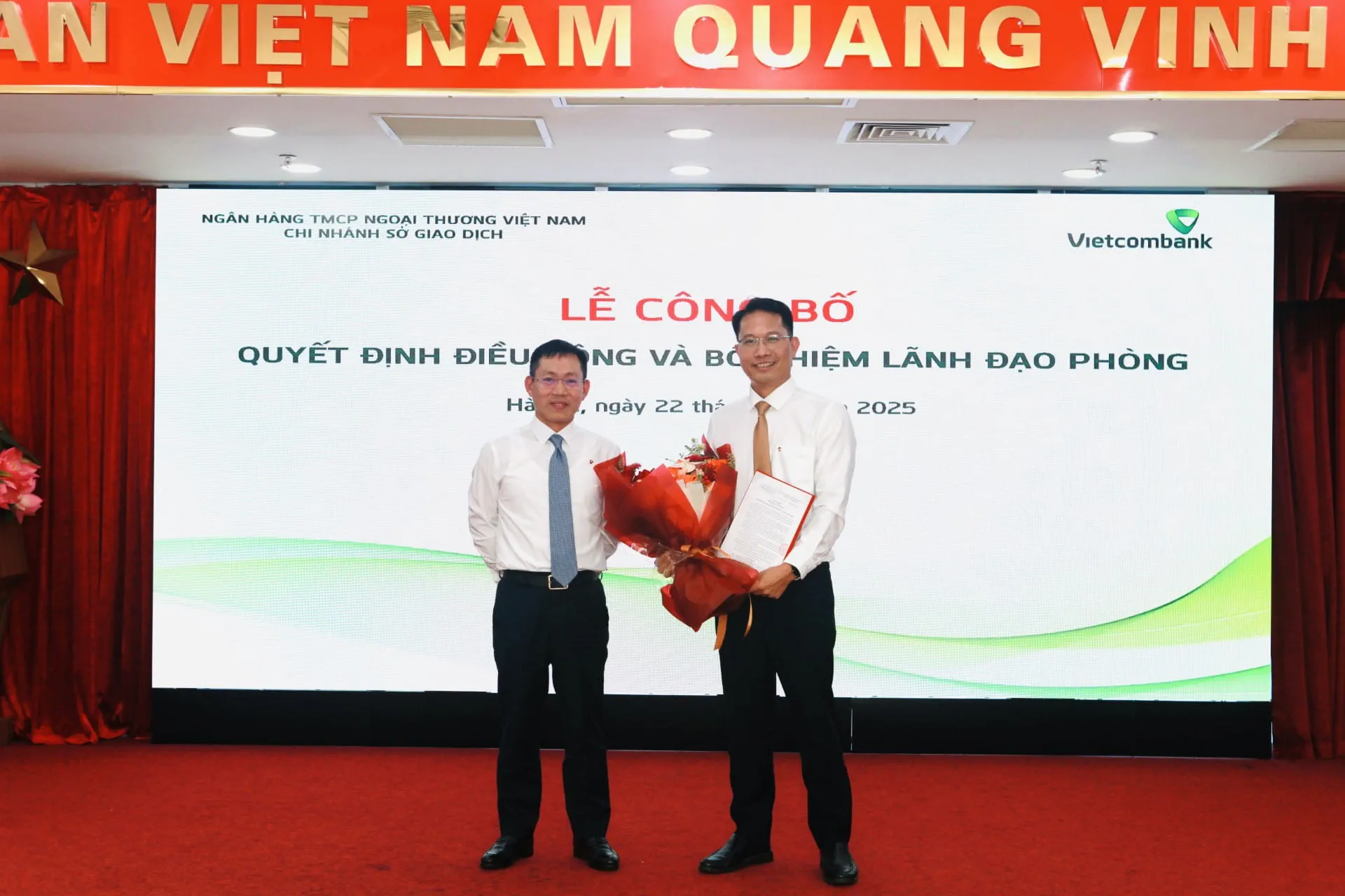 Ông Đặng Kiên Định - Bí thư Đảng ủy, Giám đốc Vietcombank Sở giao dịch trao Quyết định và tặng hoa chúc mừng ông Đào Đình Thân – tân Trưởng phòng Hành chính quản trị