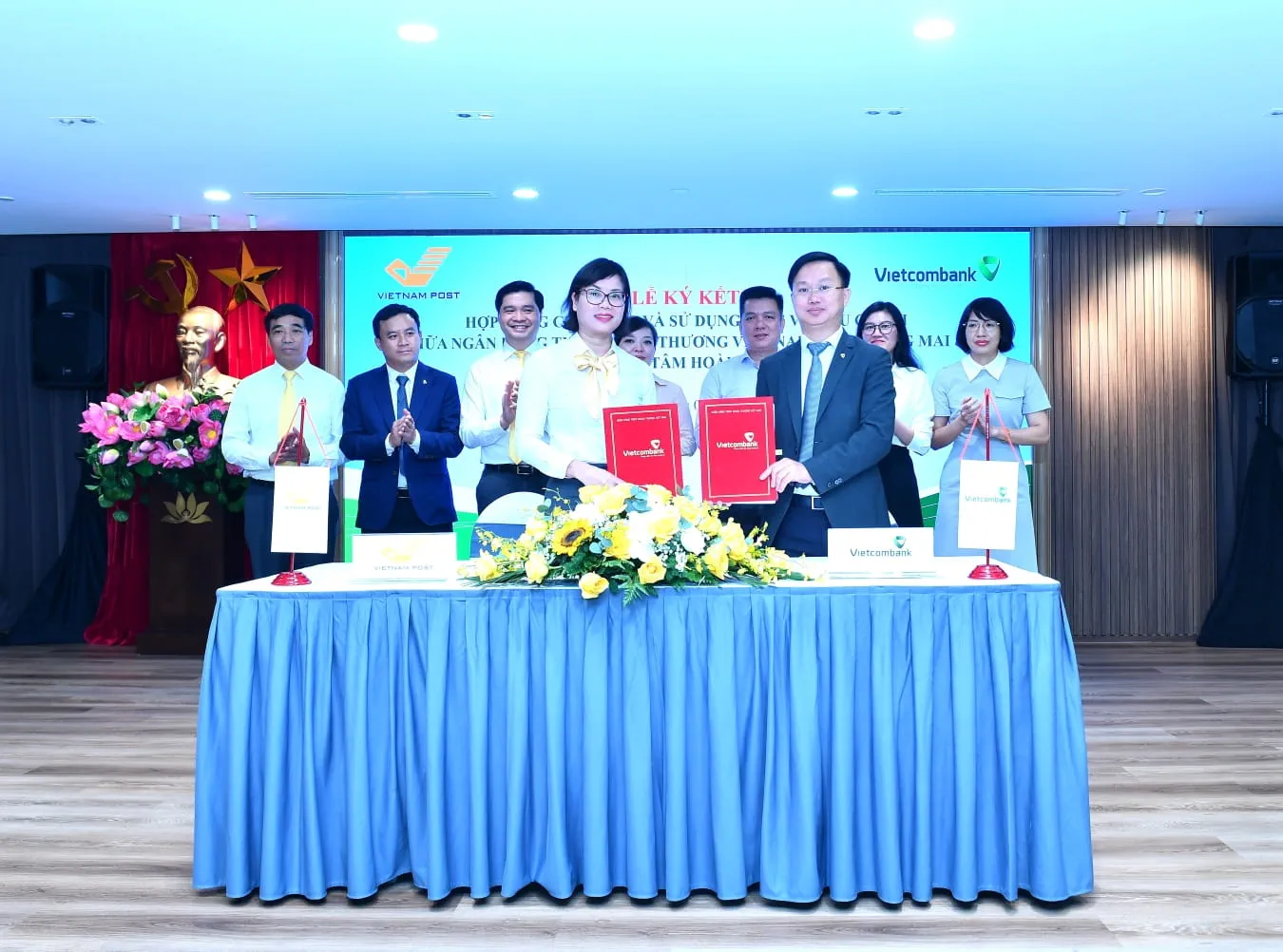 Ông Nguyễn Đình Minh - Phó Giám đốc Vietcombank Hoàng Mai (bên phải) và bà Nguyễn Thị Thanh Vân - Giám đốc Bưu điện Trung tâm Hoàn Kiếm thực hiện nghi thức ký kết trước sự chứng kiến của lãnh đạo các đơn vị